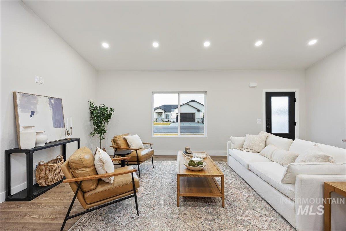Living room with recessed lighting, light wood-type flooring, and plenty of natural light