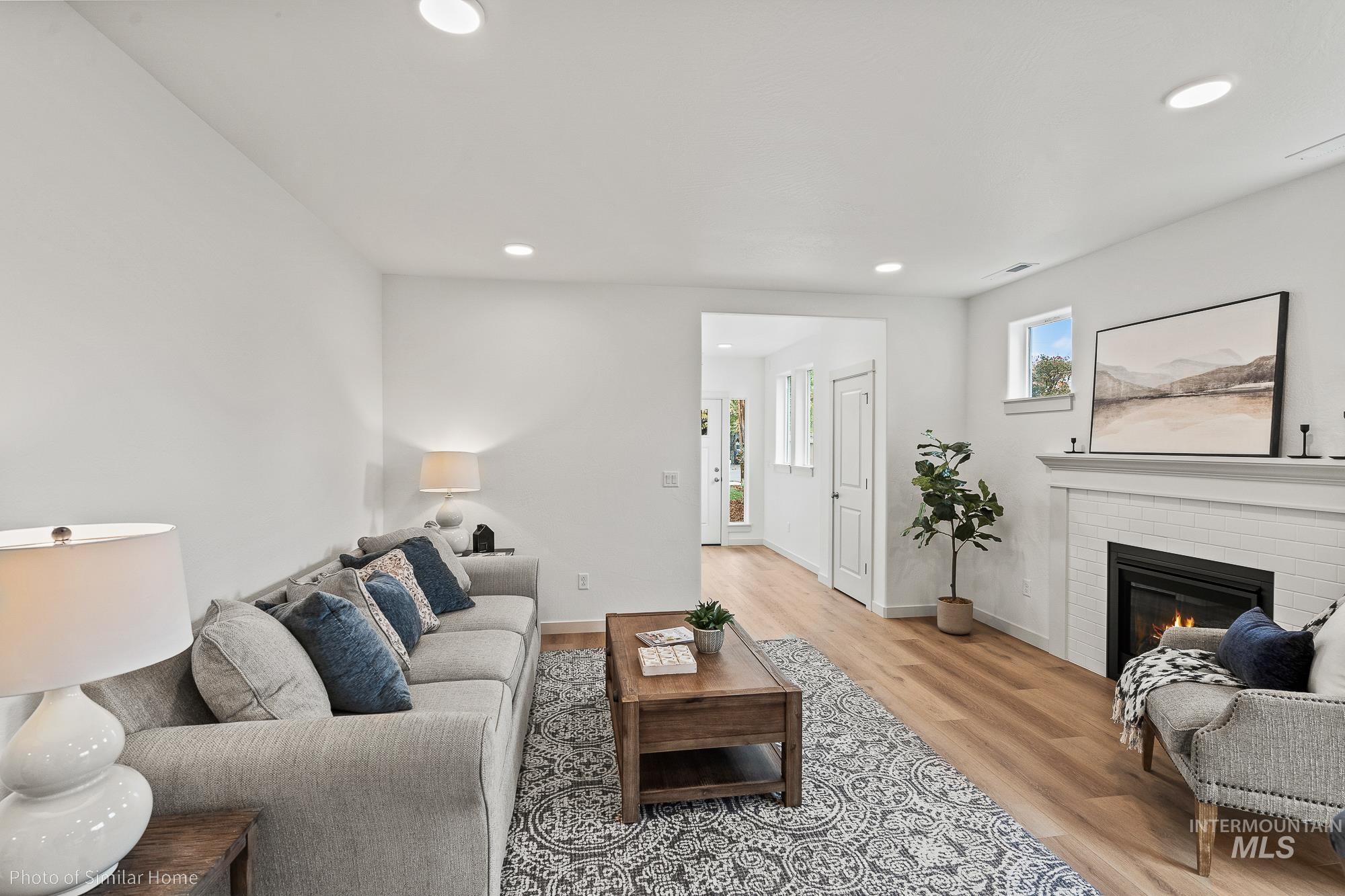 Living area featuring a fireplace, recessed lighting, and light wood-style floors