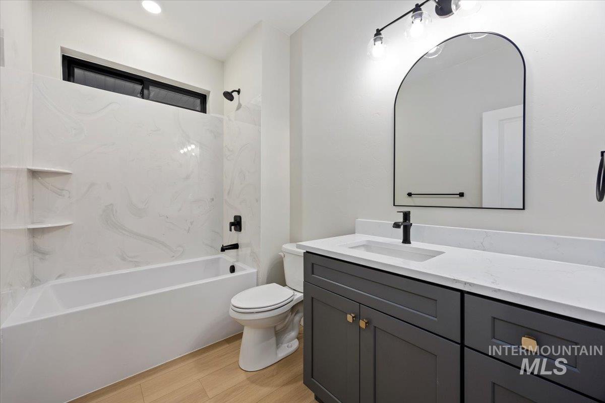 Full bathroom featuring vanity, bathtub / shower combination, and light wood-style flooring
