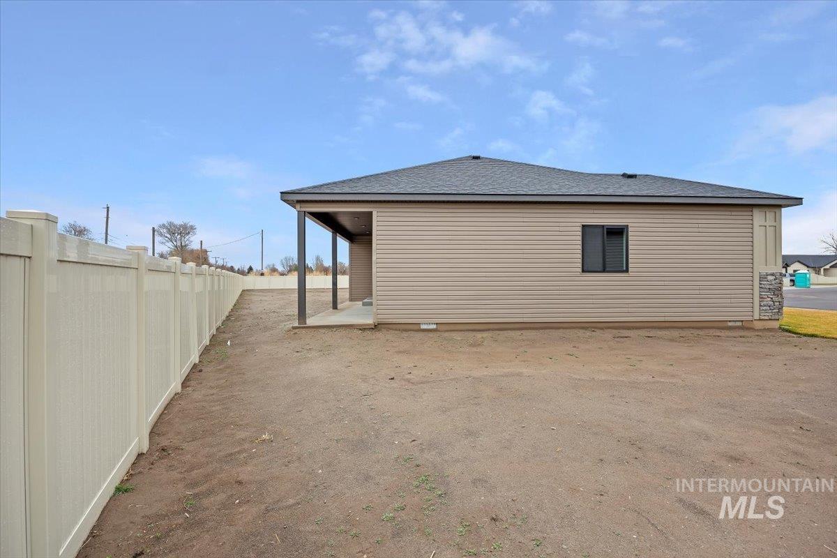 View of home's exterior featuring a patio area and a shingled roof