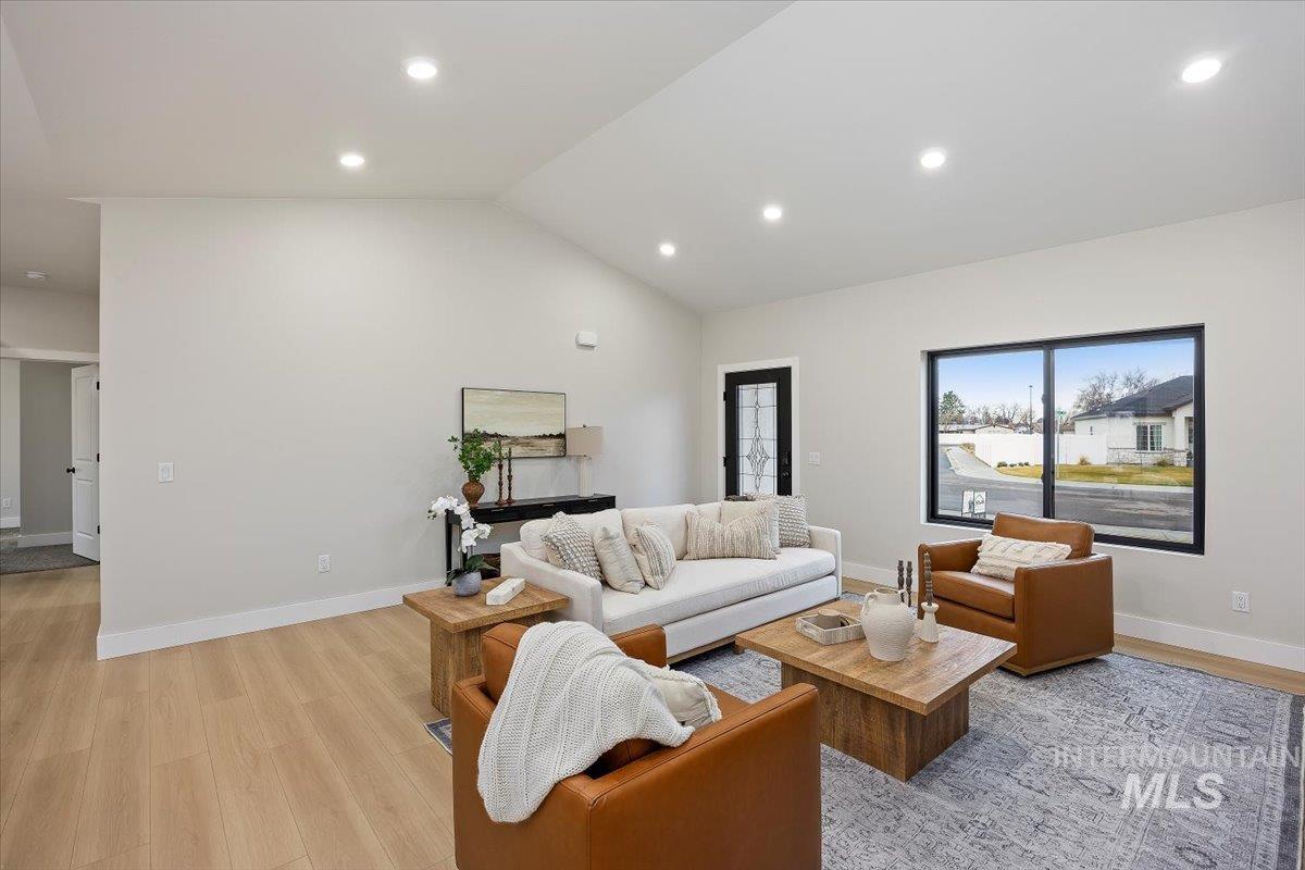 Living area featuring lofted ceiling, light wood finished floors, and recessed lighting