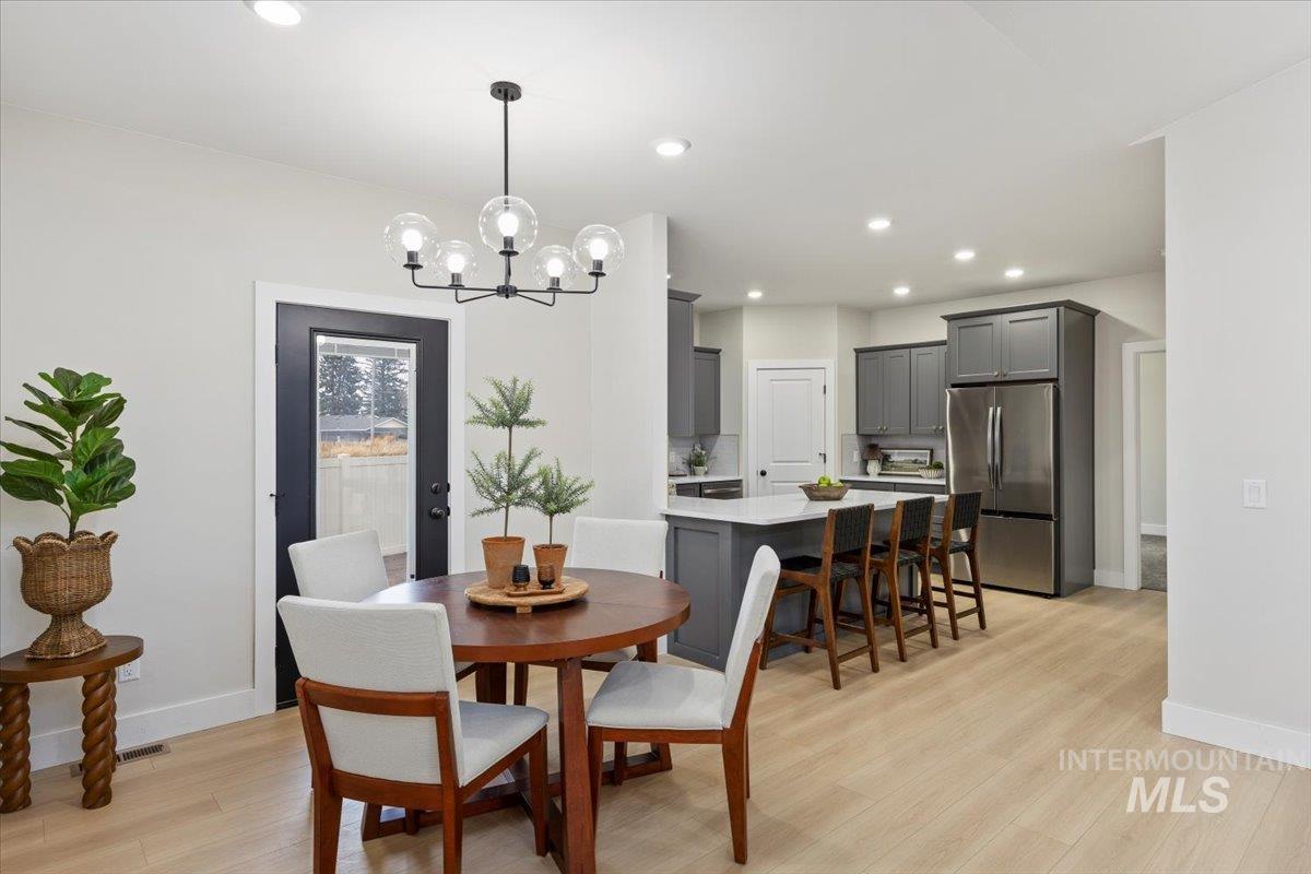 Dining space with recessed lighting, light wood-style flooring, and a chandelier