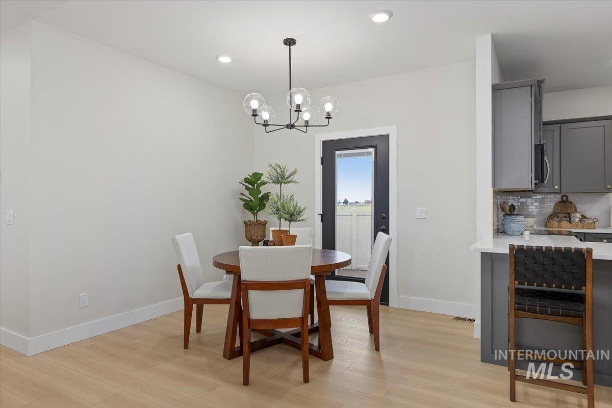 Dining area with light wood-type flooring, recessed lighting, and a chandelier