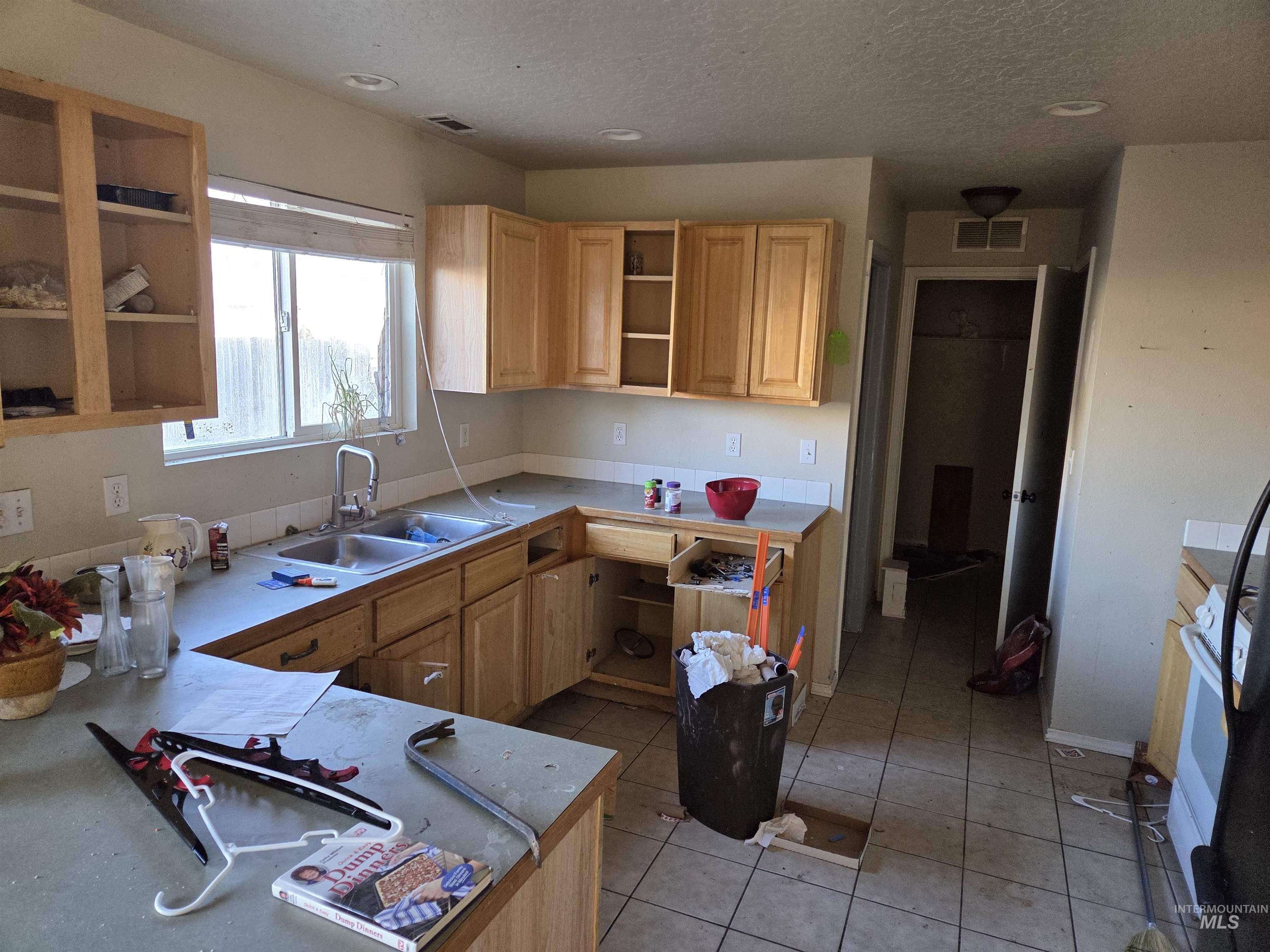 Kitchen featuring open shelves, light tile patterned flooring, light countertops, light brown cabinets, and white stove