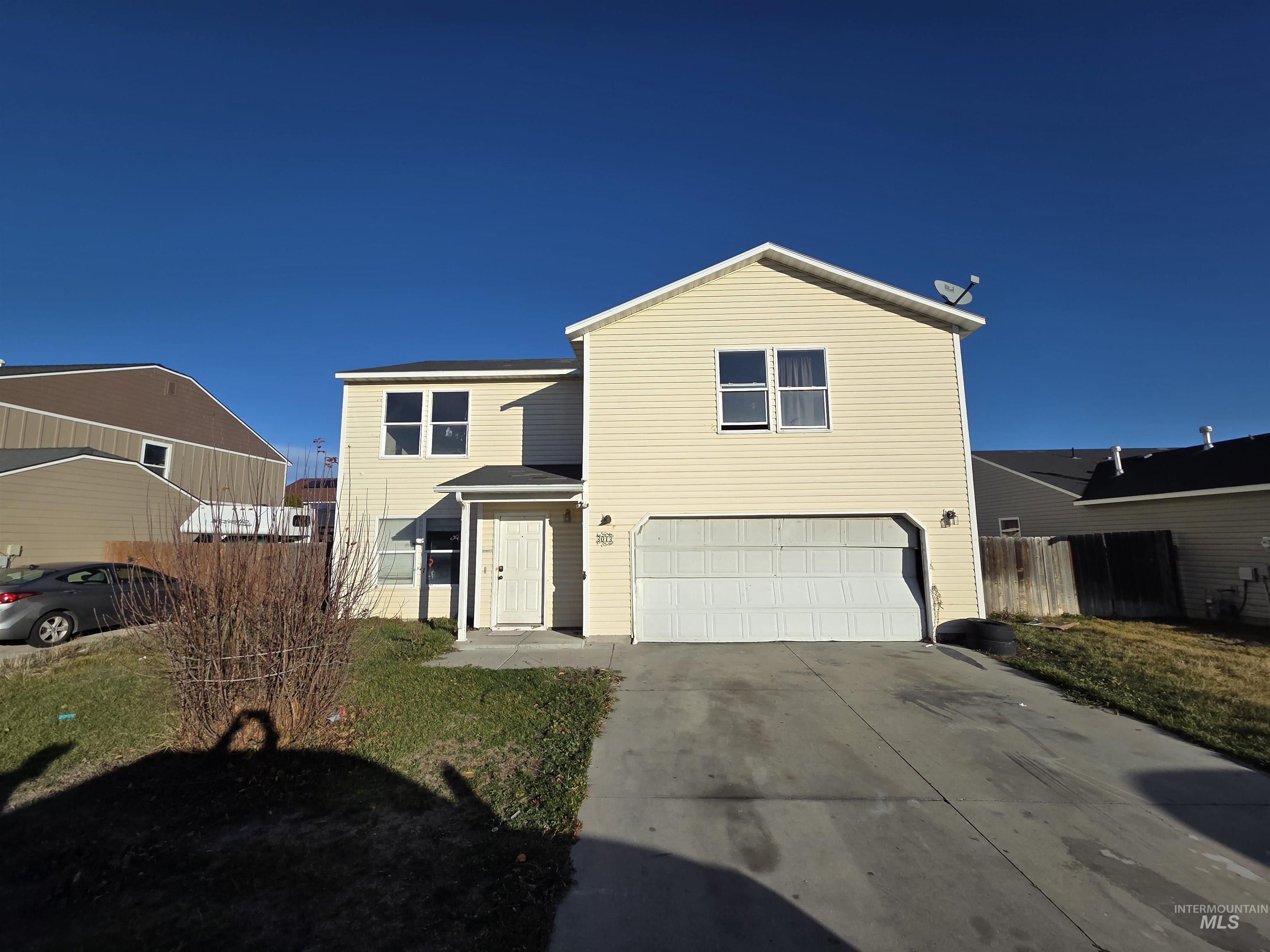 Traditional-style home featuring a garage and driveway