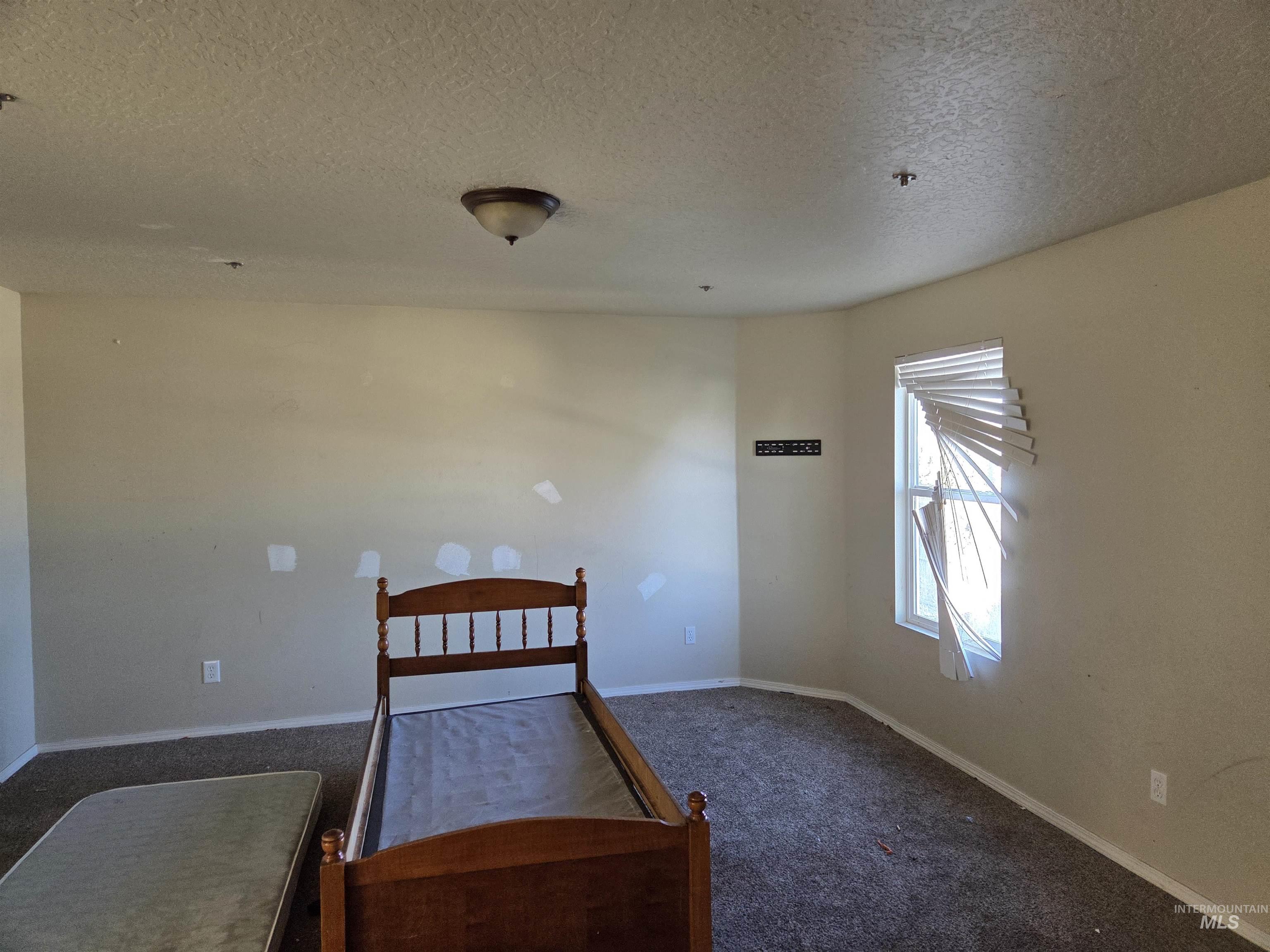 Carpeted bedroom featuring a textured ceiling