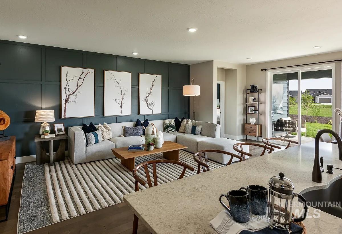 Living room with a decorative wall, wood finished floors, an accent wall, and recessed lighting