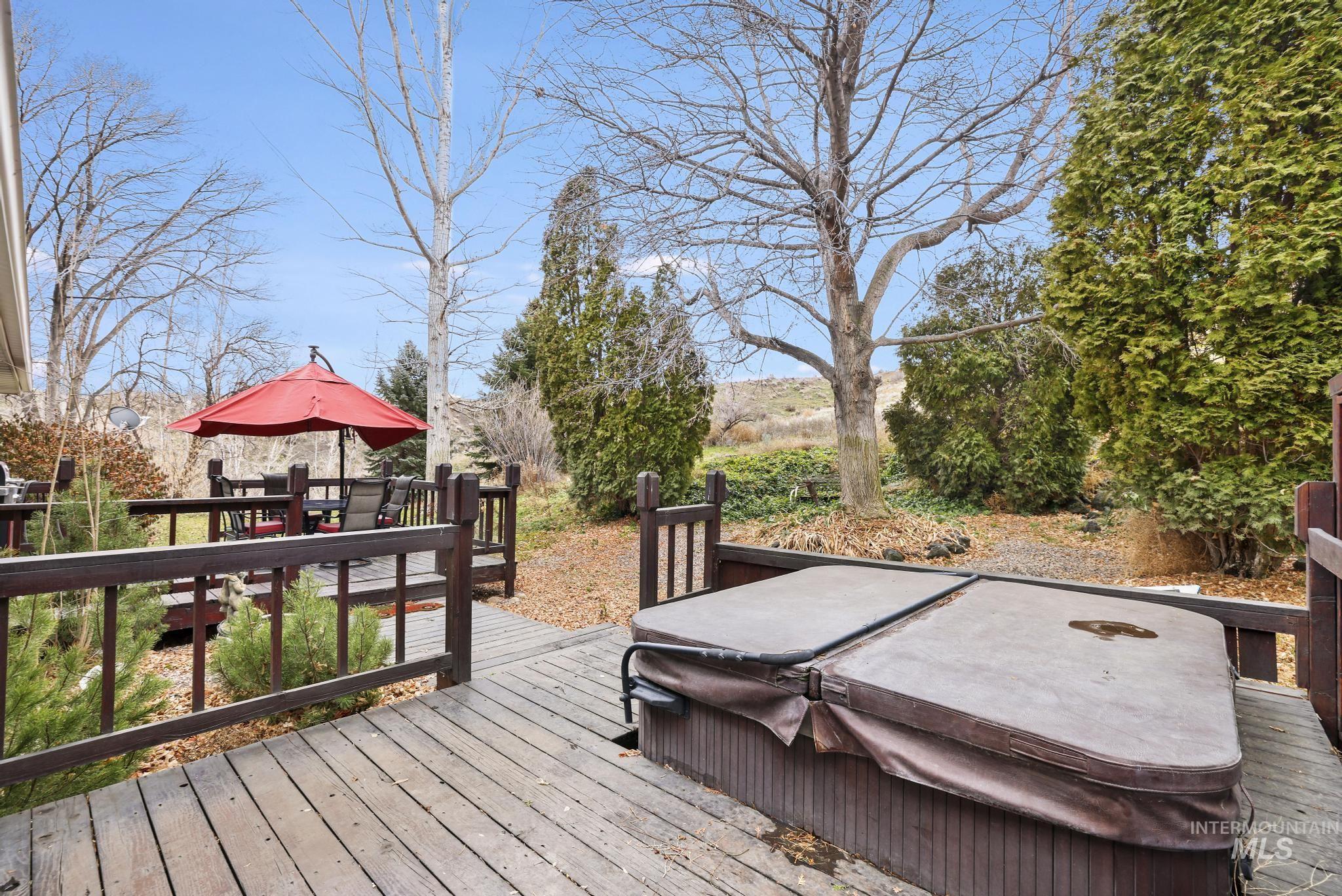 Deck with a hot tub and outdoor dining space