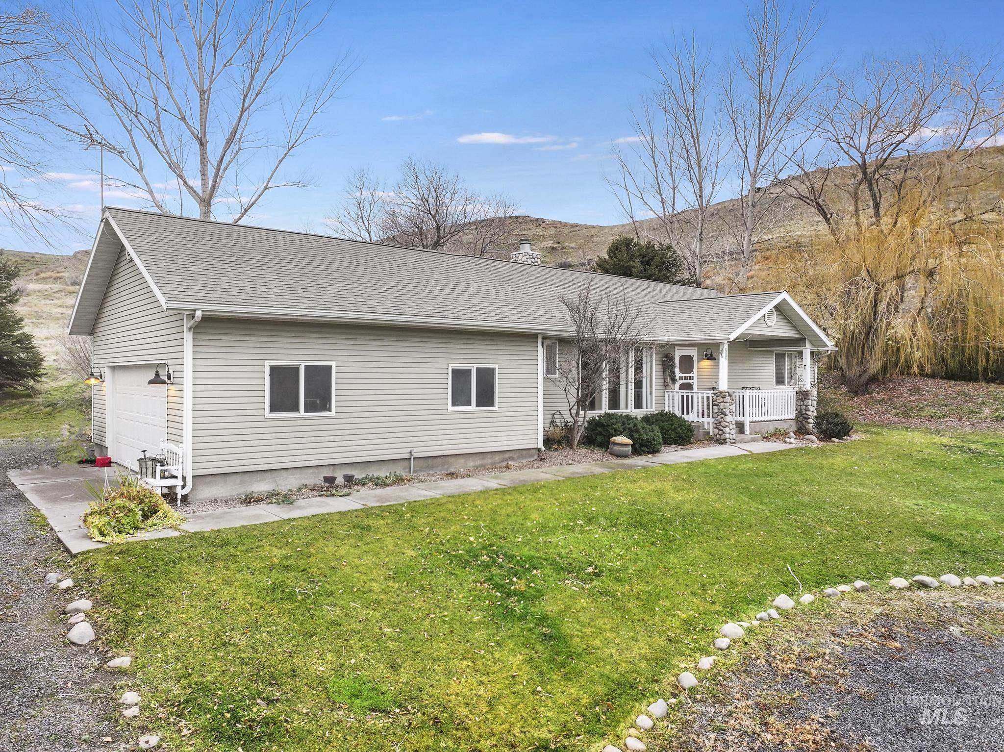 Ranch-style house with covered porch, a front lawn, and roof with shingles