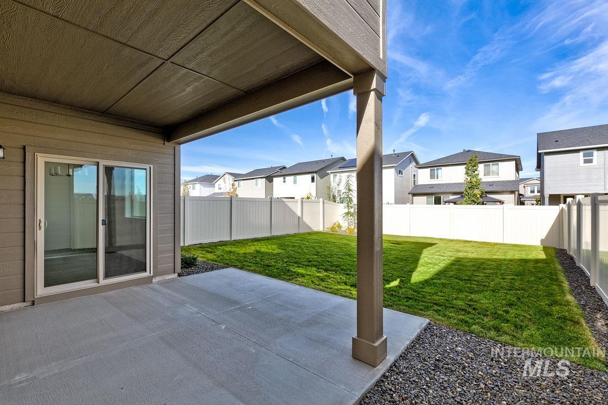 Fenced backyard featuring a patio and a residential view