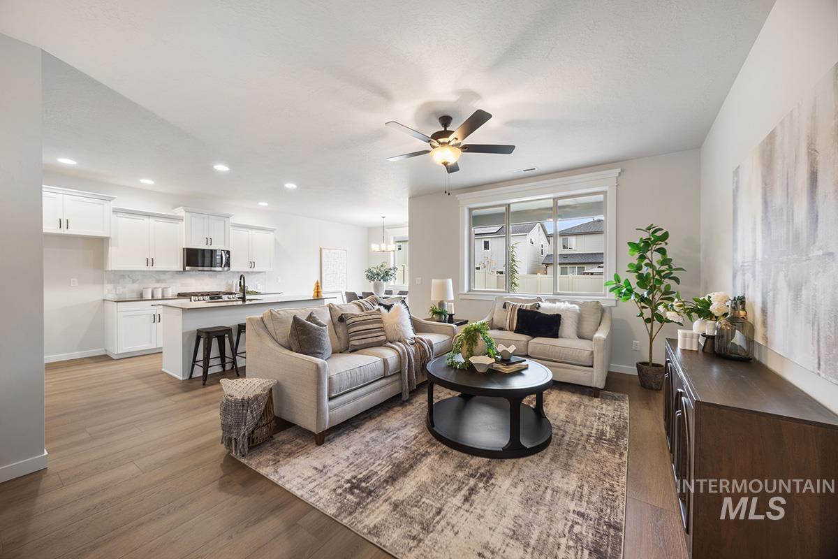 Living room with dark wood-style flooring, ceiling fan, and recessed lighting