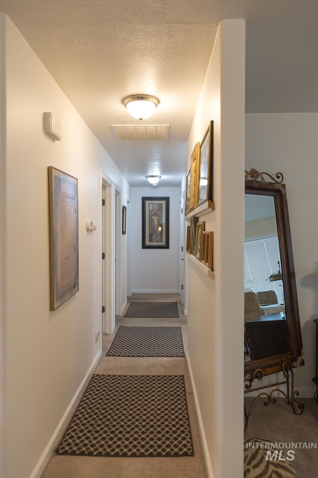Corridor featuring carpet floors and a textured ceiling