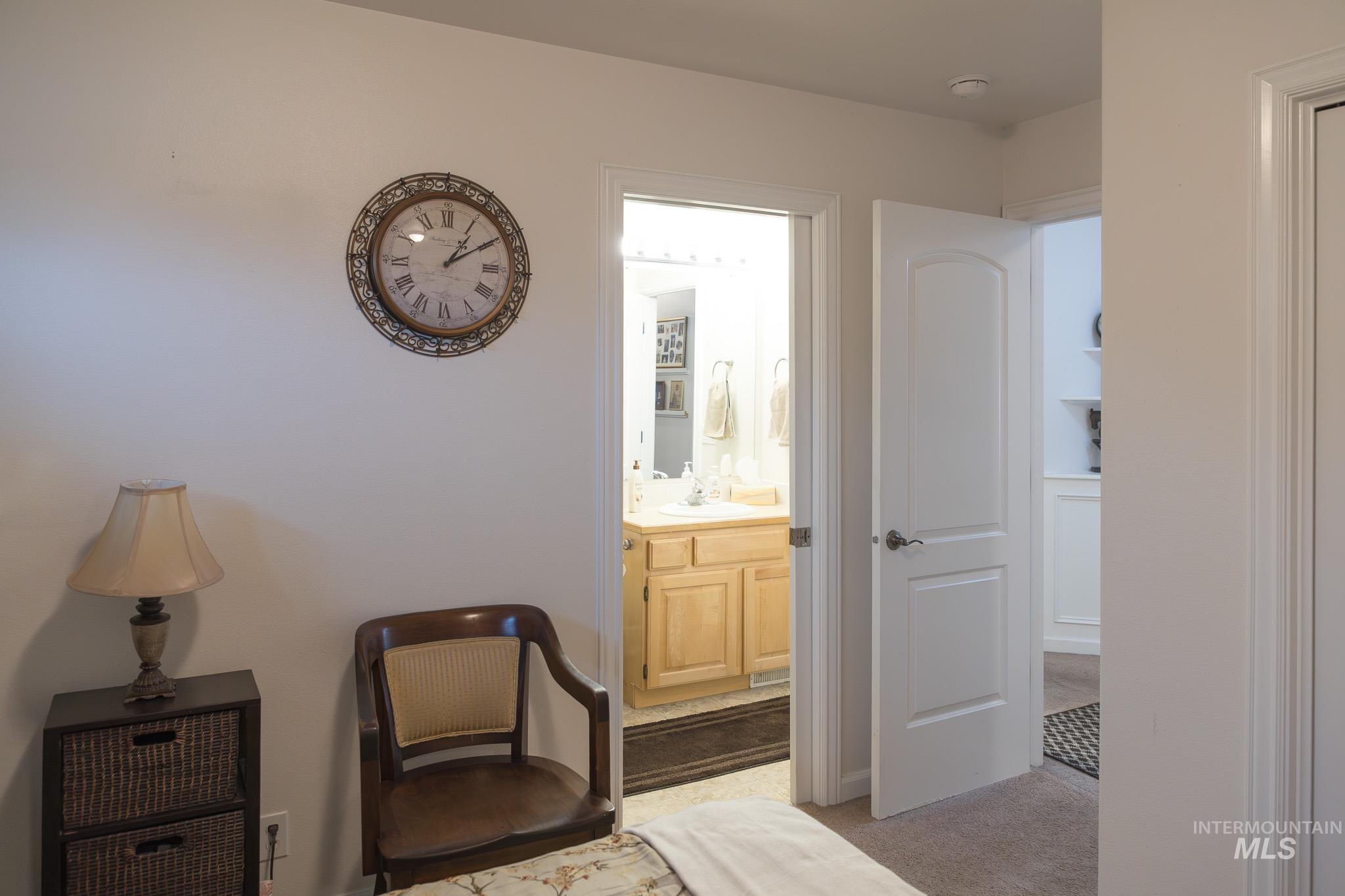 Bedroom featuring light carpet and connected bathroom