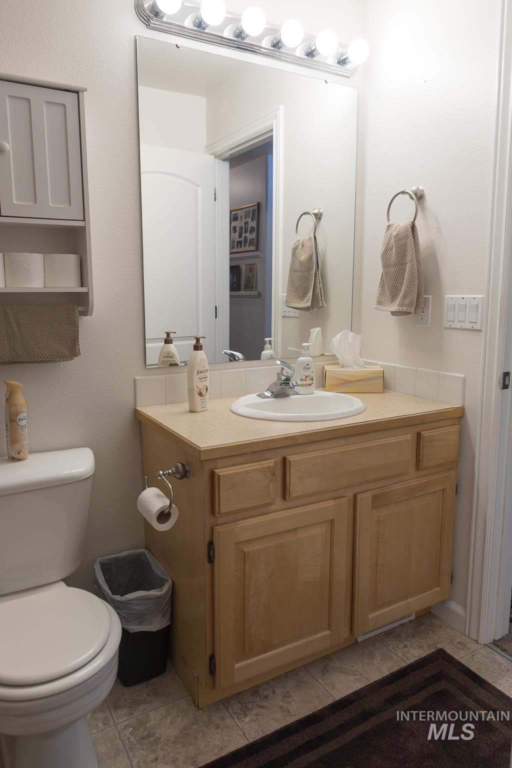 Half bathroom featuring vanity and light tile patterned flooring