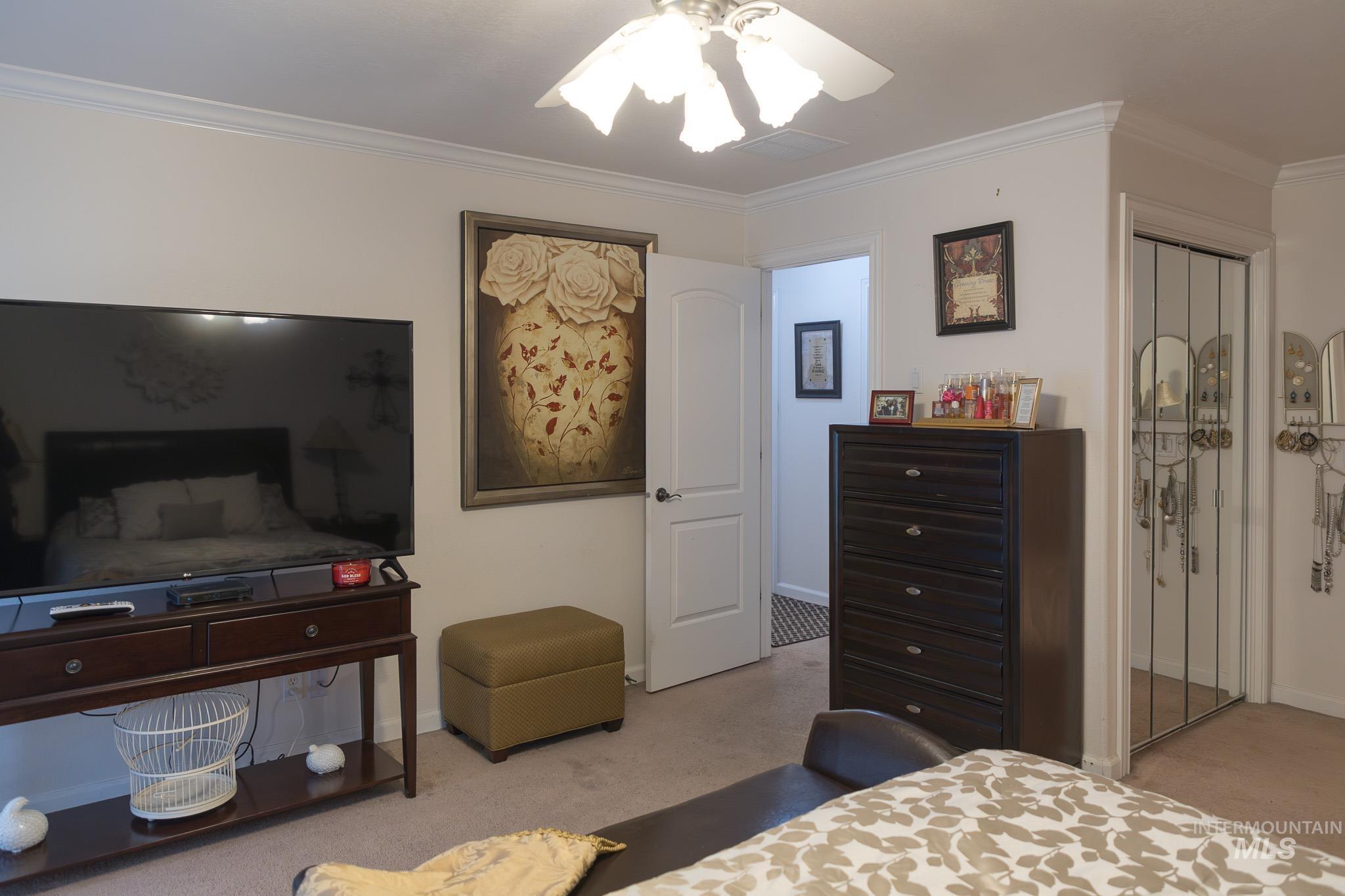 Bedroom featuring ornamental molding, ceiling fan, and a closet