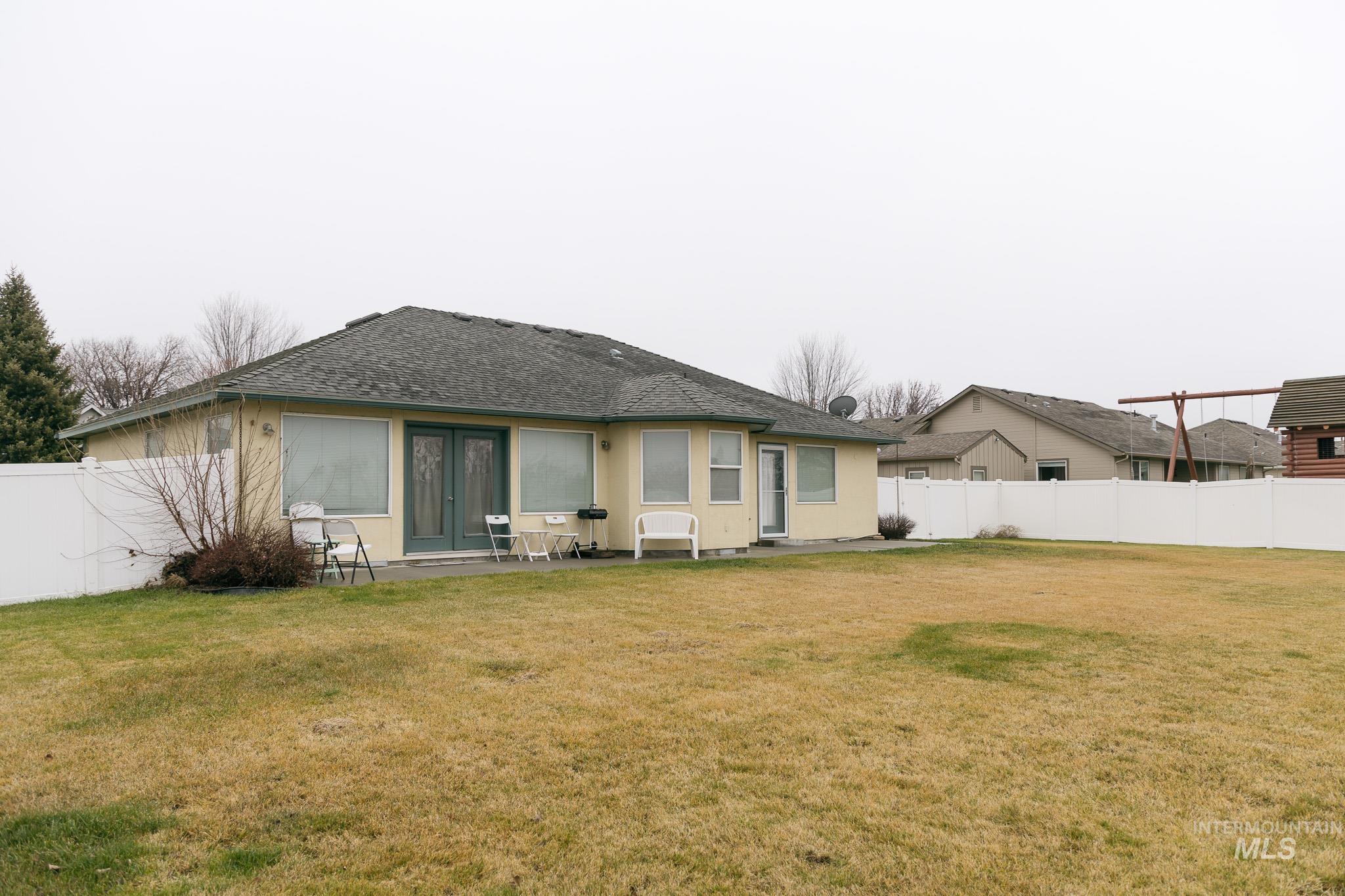 Rear view of property featuring a fenced backyard, a patio area, a shingled roof, and french doors
