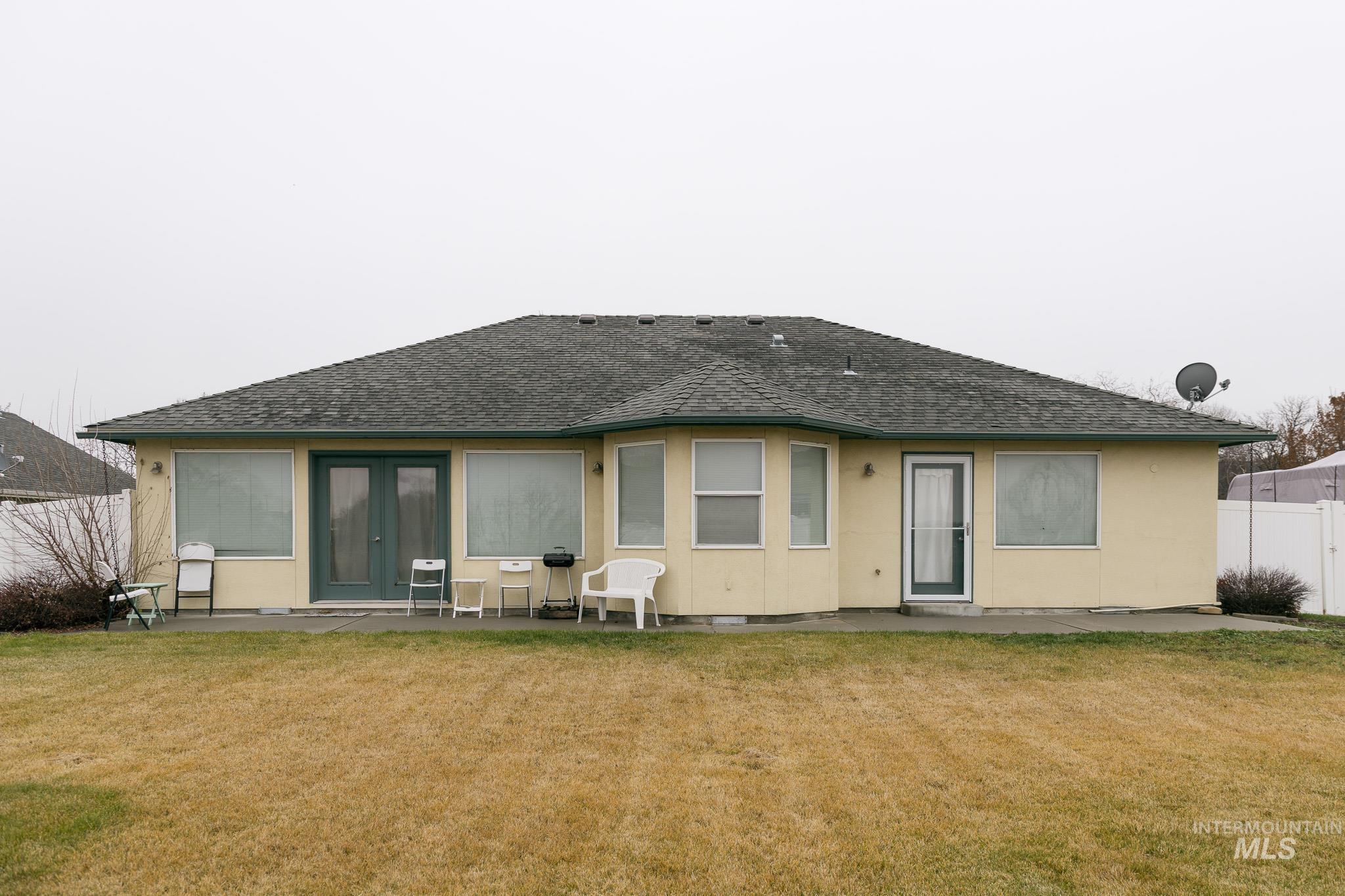 Rear view of property with a patio area, a shingled roof, stucco siding, and french doors