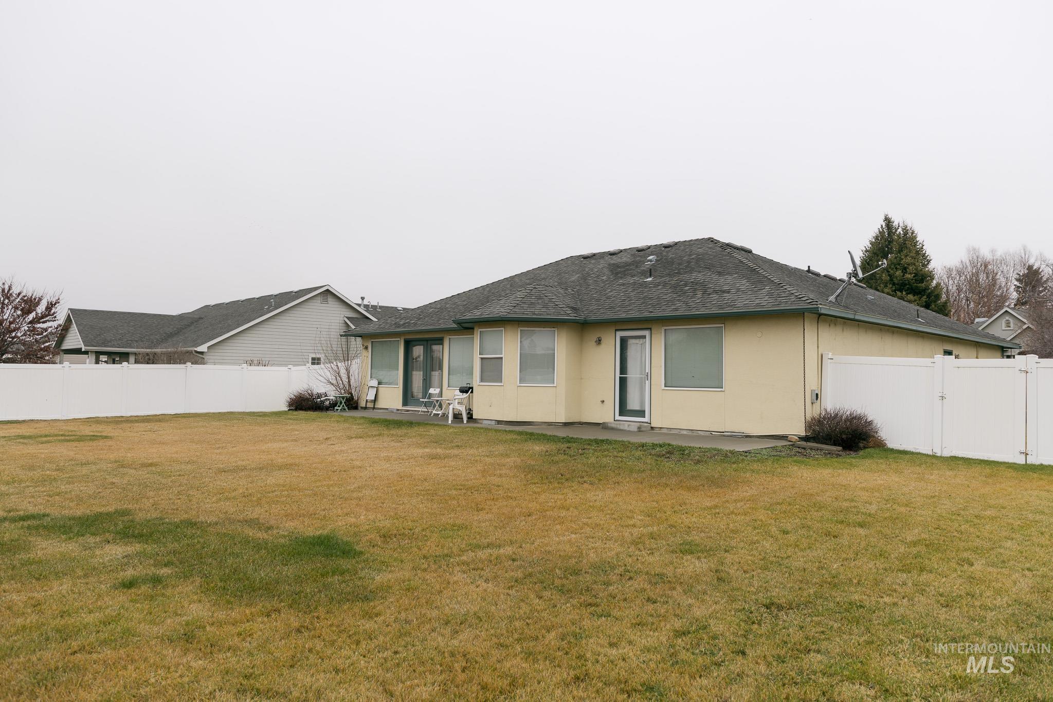 Back of house with a patio, a fenced backyard, and roof with shingles