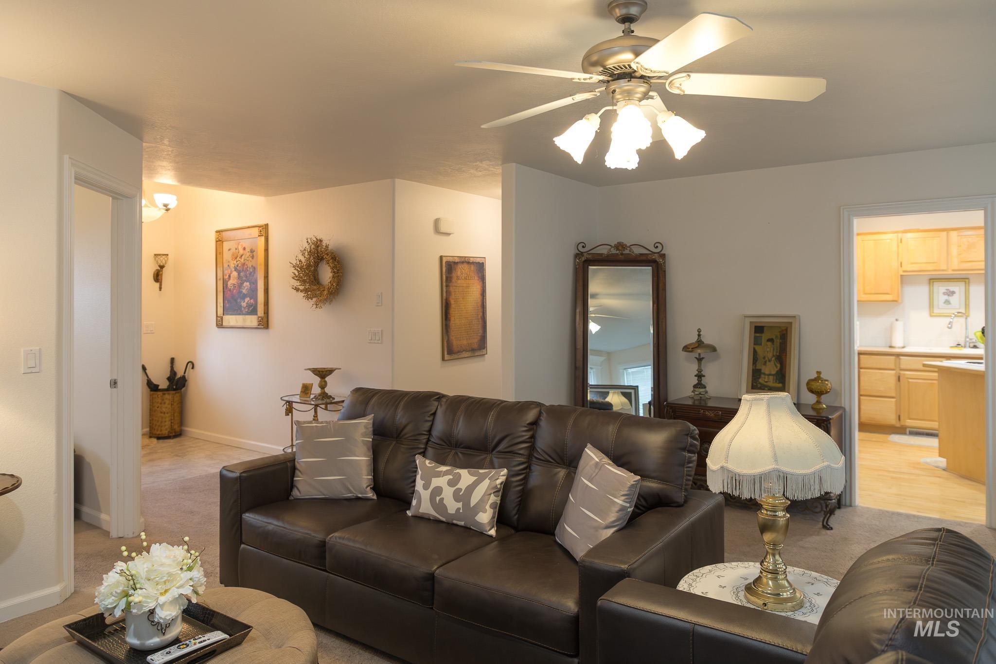 Living area featuring a ceiling fan and light carpet