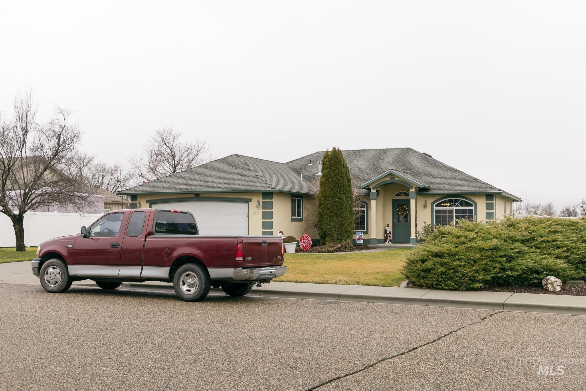 Ranch-style home with roof with shingles, a front yard, and stucco siding