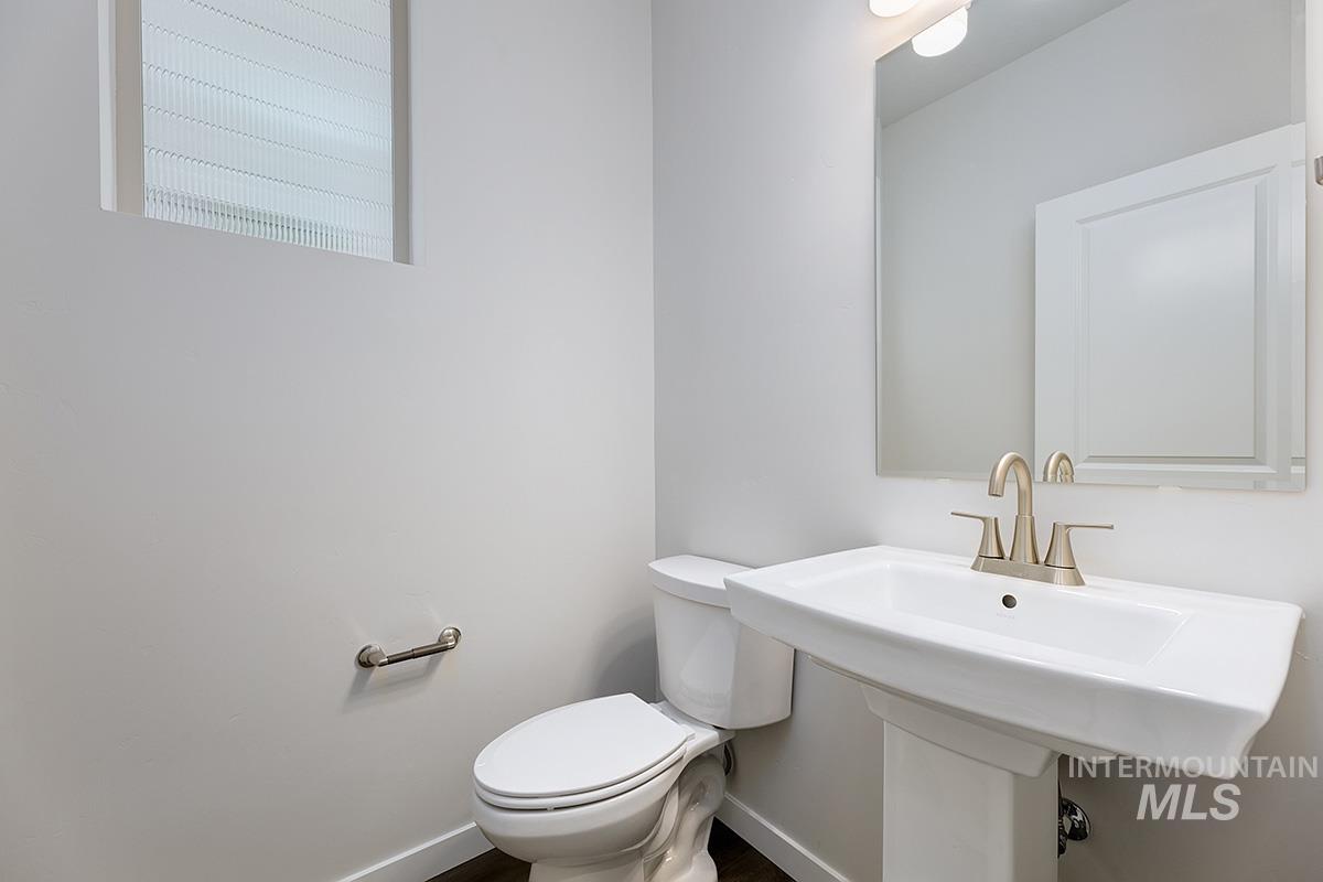 Half bath featuring toilet and baseboards