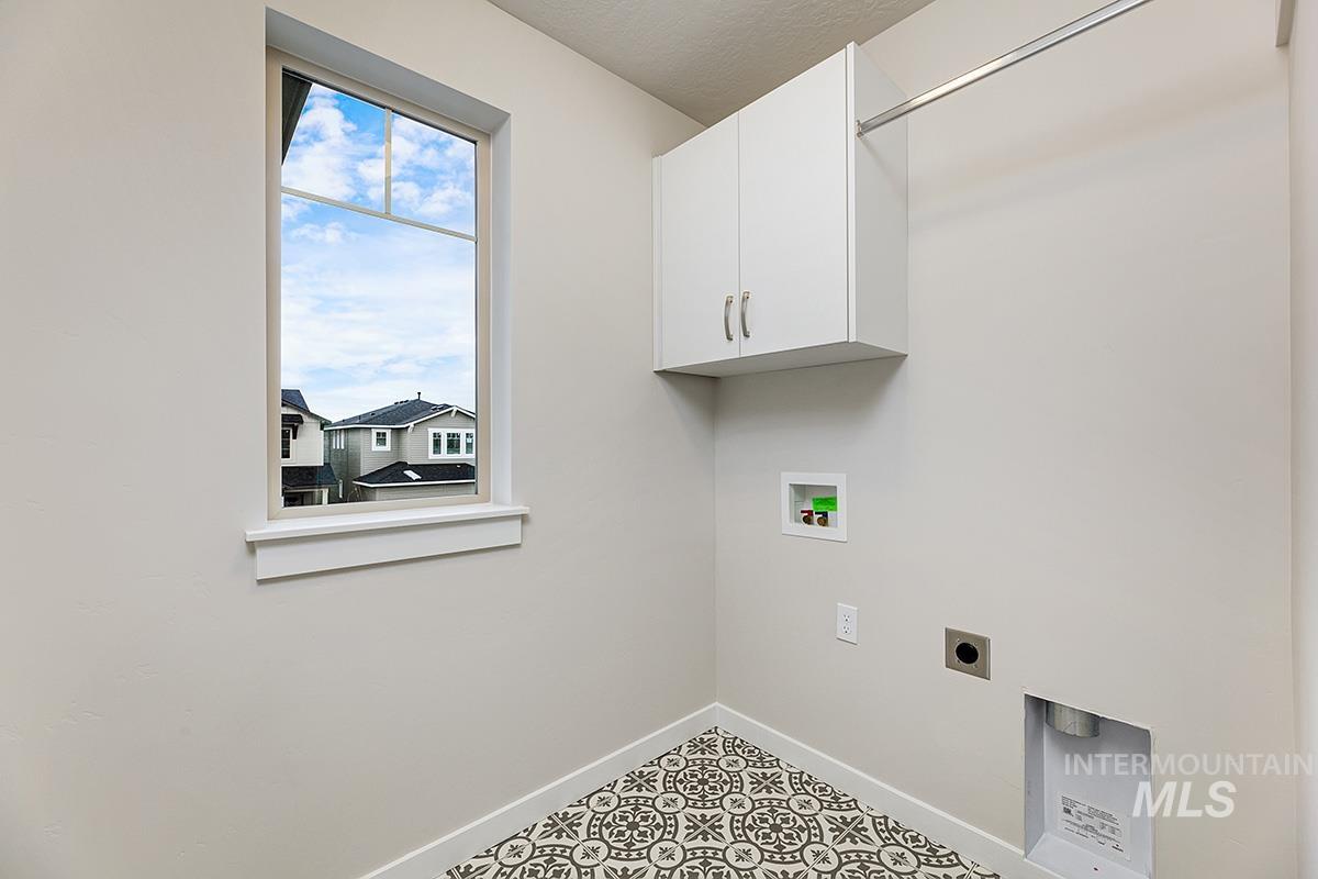 Laundry room featuring hookup for an electric dryer, washer hookup, cabinet space, and a textured ceiling