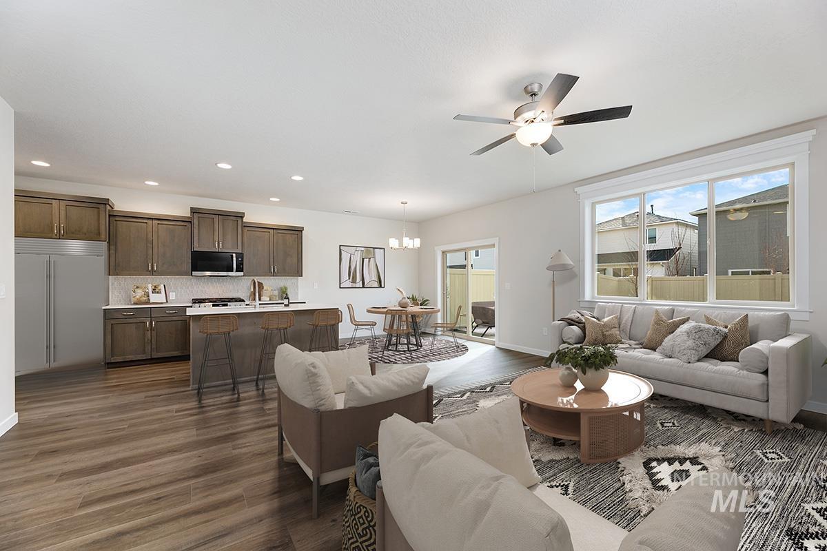 Living room with ceiling fan, a chandelier, dark wood finished floors, and recessed lighting