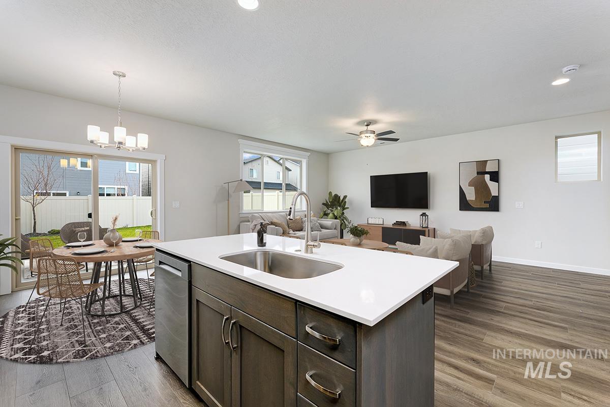 Kitchen with dark brown cabinets, open floor plan, decorative light fixtures, dark wood-style floors, and recessed lighting
