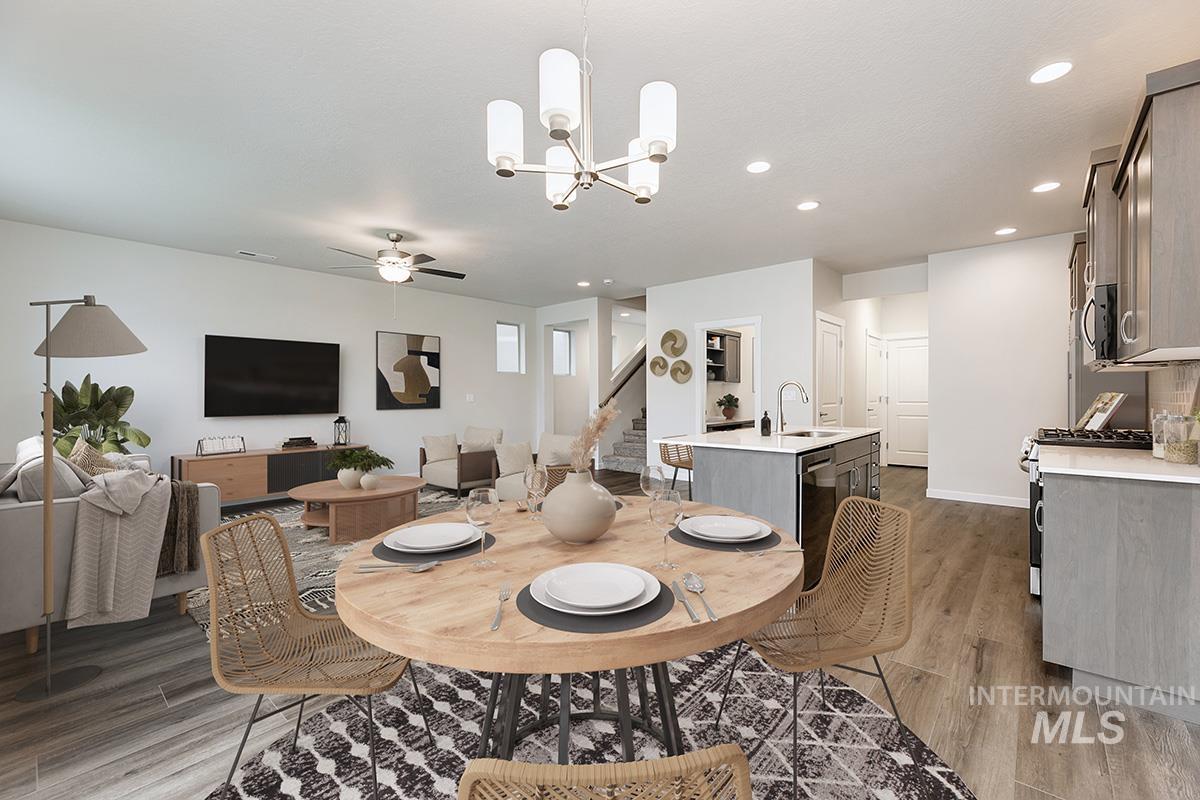 Dining area with light wood finished floors, recessed lighting, a chandelier, stairway, and ceiling fan