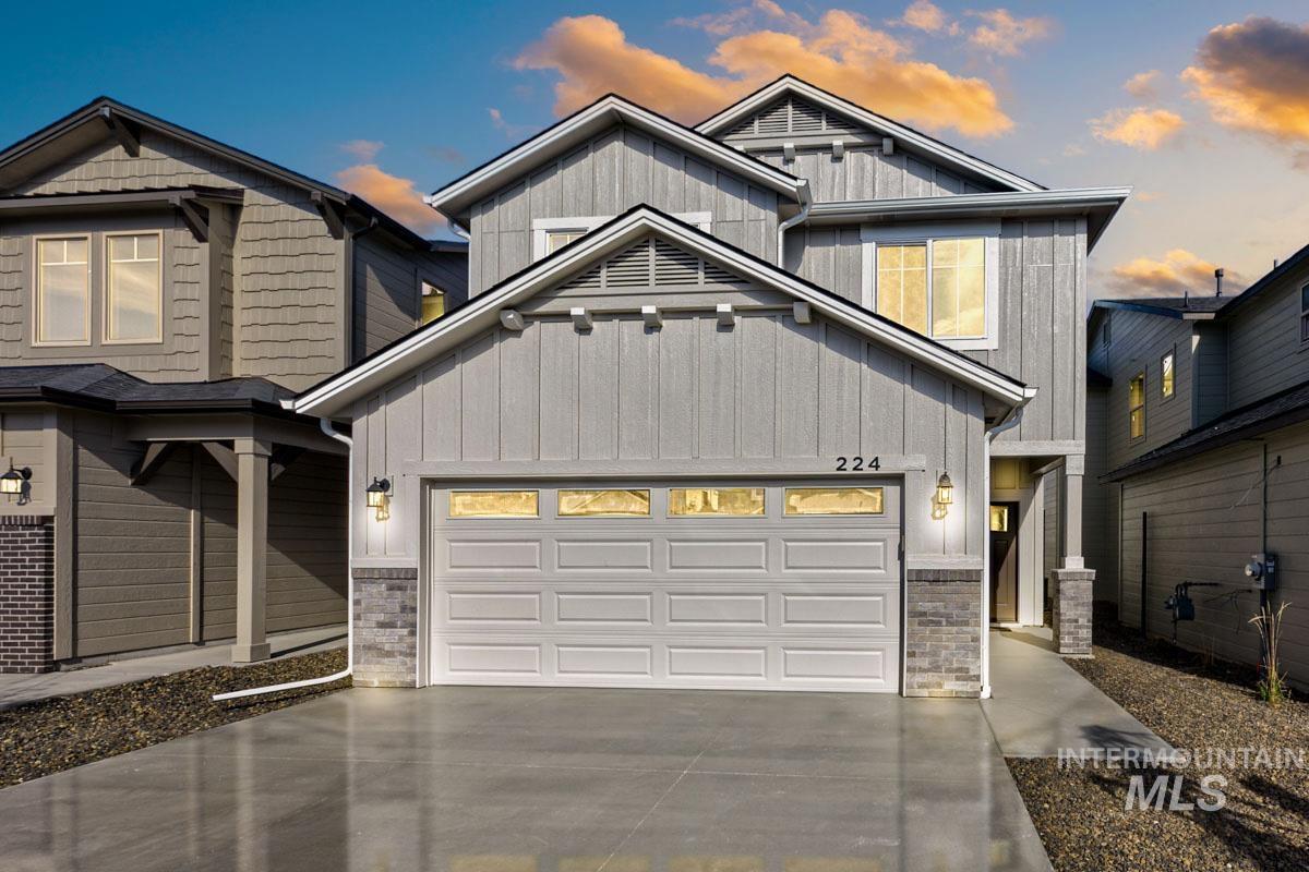 Craftsman-style home with stone siding, board and batten siding, concrete driveway, and an attached garage