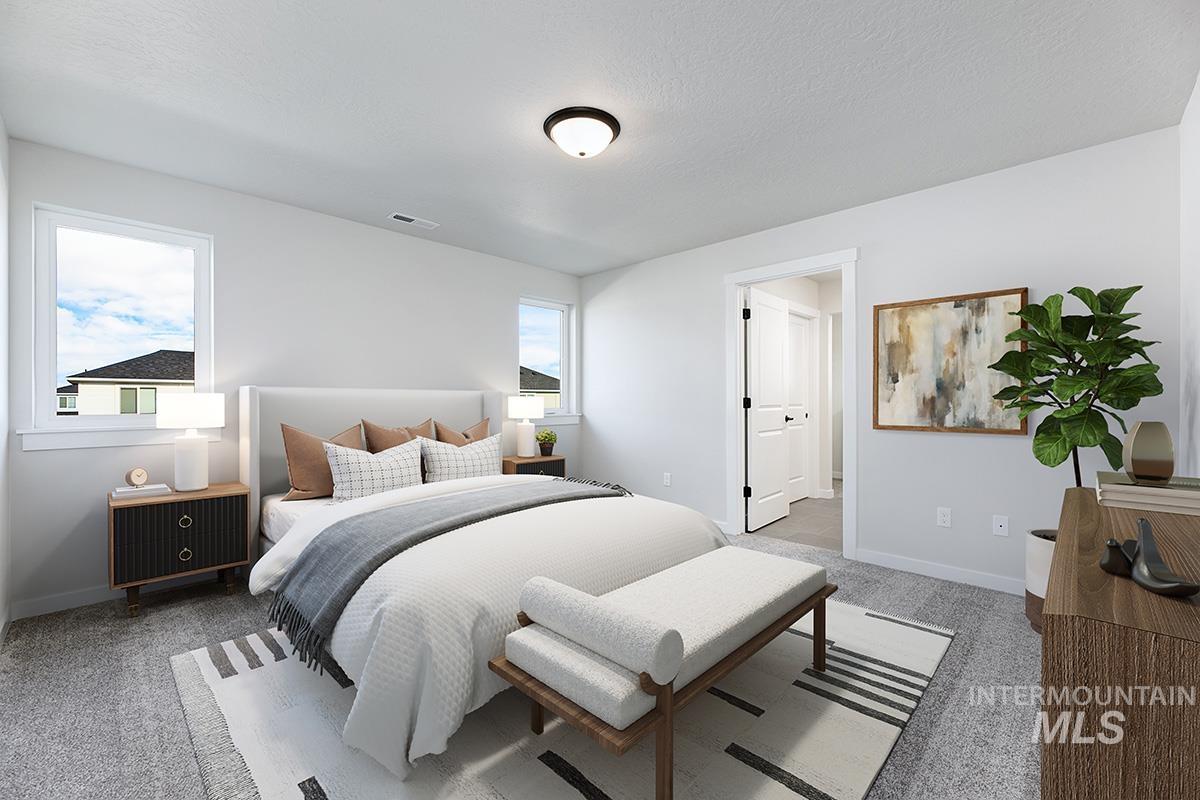 Bedroom featuring light colored carpet and a textured ceiling