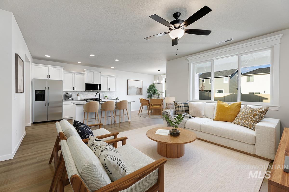 Living area featuring recessed lighting, light wood-style floors, ceiling fan, and a textured ceiling