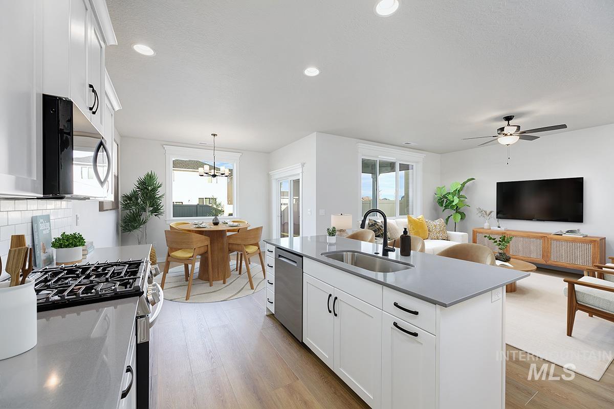 Kitchen with white cabinetry, appliances with stainless steel finishes, decorative backsplash, decorative light fixtures, and recessed lighting