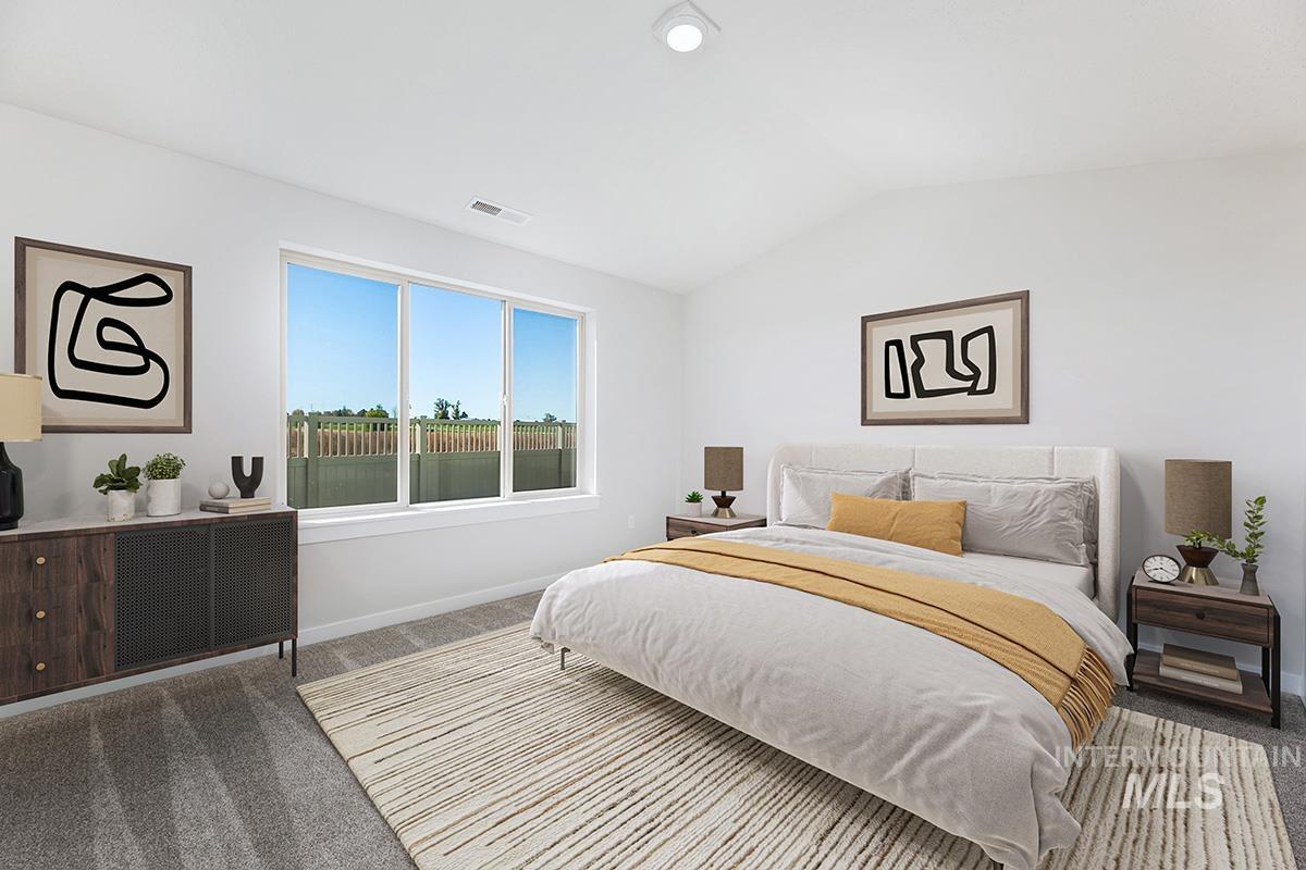 Bedroom featuring carpet floors and lofted ceiling
