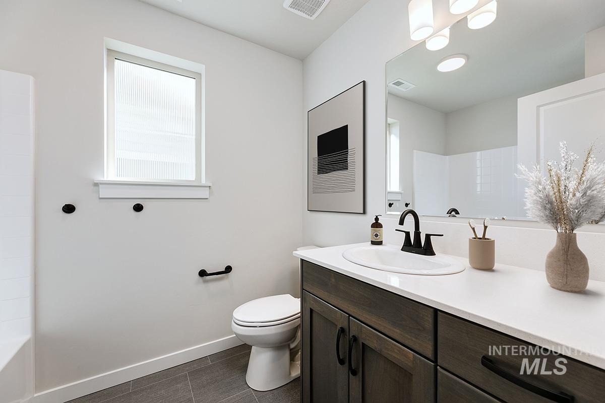 Full bath featuring vanity and toilet