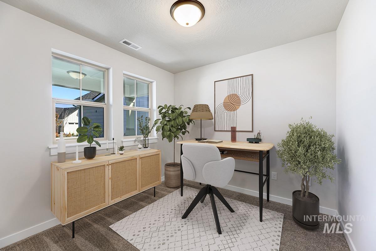 Office area featuring dark colored carpet and a textured ceiling
