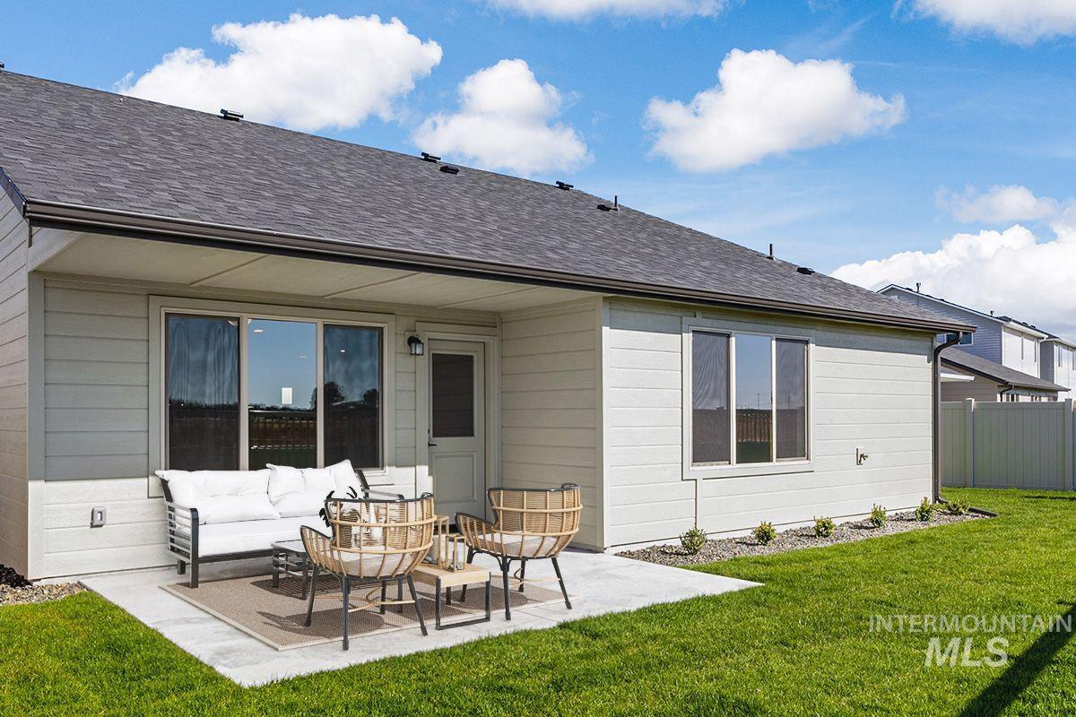Rear view of property with roof with shingles, a patio, and an outdoor hangout area