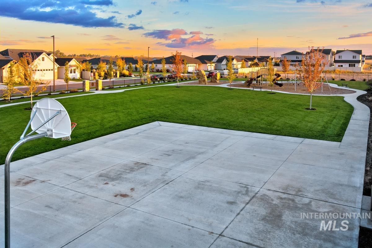 Patio terrace at dusk featuring a residential view and a yard