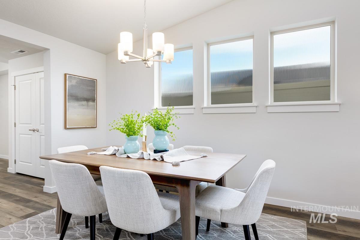 Dining room with dark wood finished floors and a chandelier