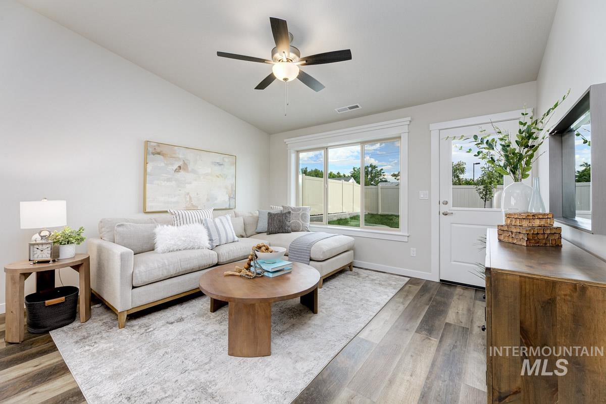 Living area featuring lofted ceiling, wood finished floors, and ceiling fan