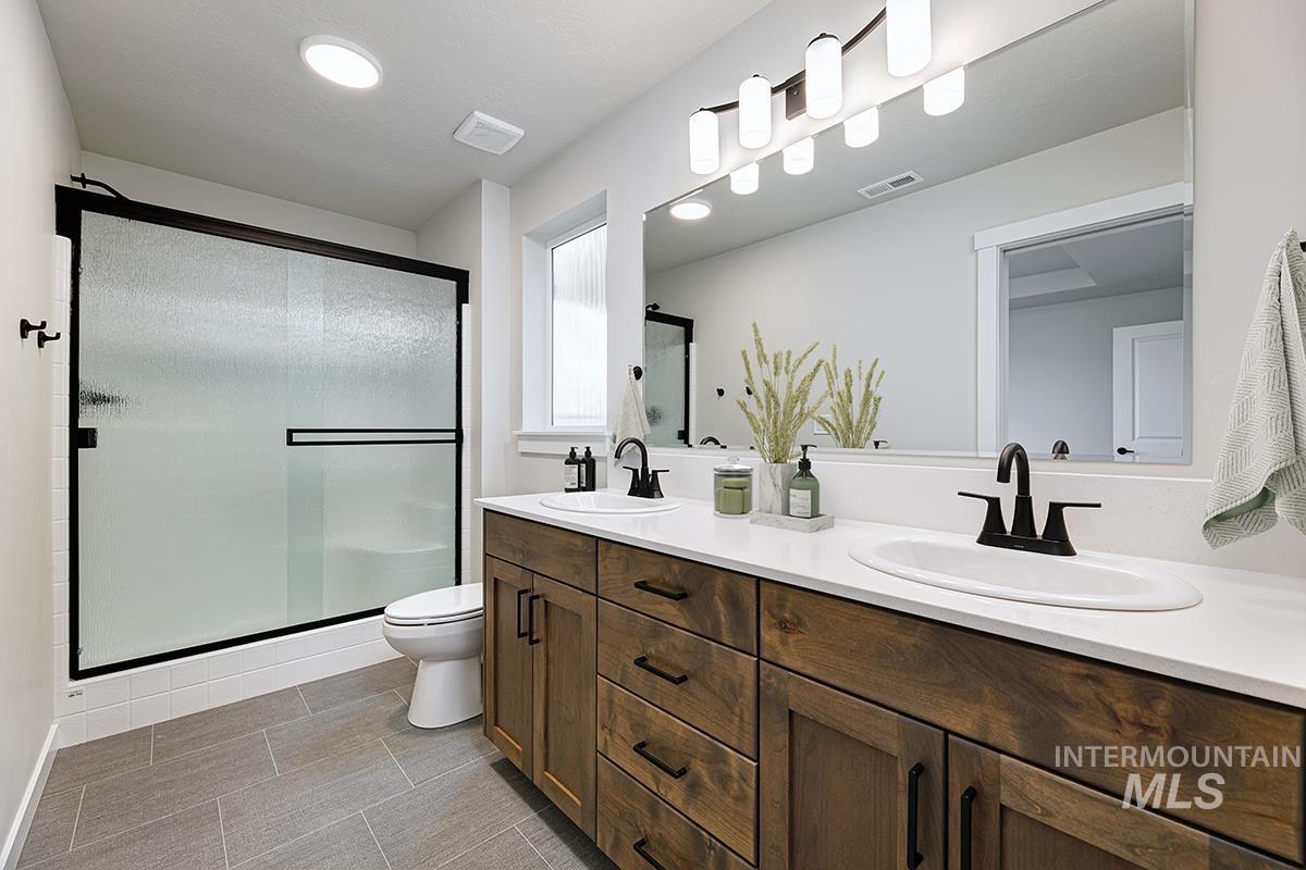 Bathroom with double vanity and a stall shower