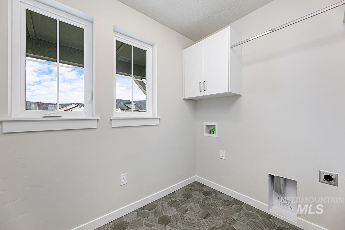 Laundry area featuring washer hookup, electric dryer hookup, a textured ceiling, and cabinet space