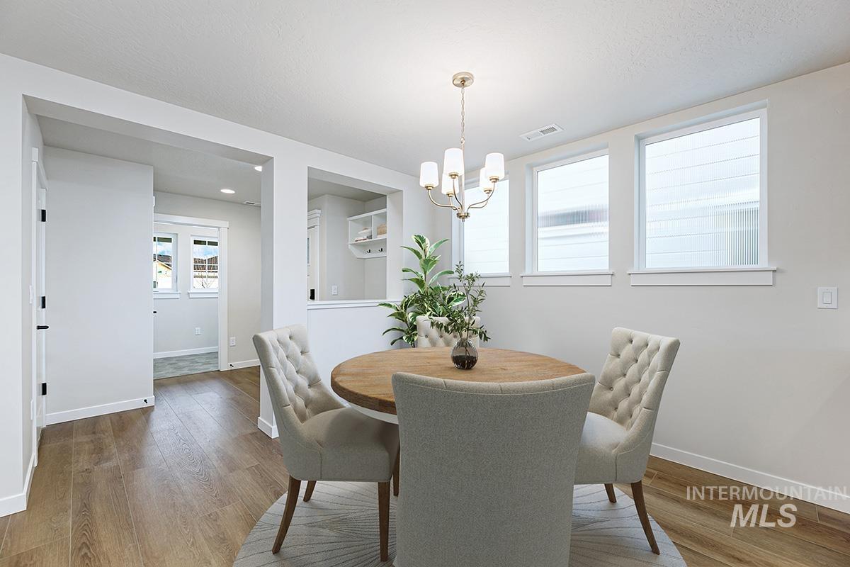 Dining area with wood finished floors and a chandelier