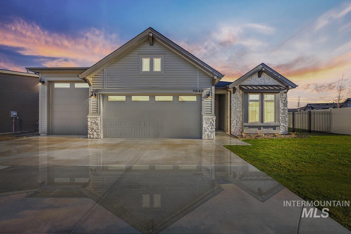 View of front of house featuring stone siding, concrete driveway, and a garage