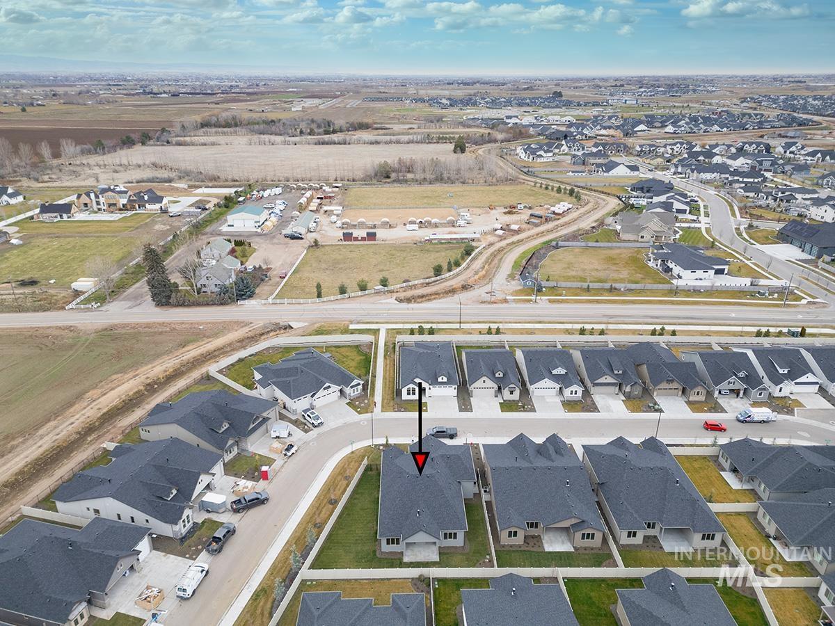 Aerial view of property and surrounding area featuring nearby suburban area