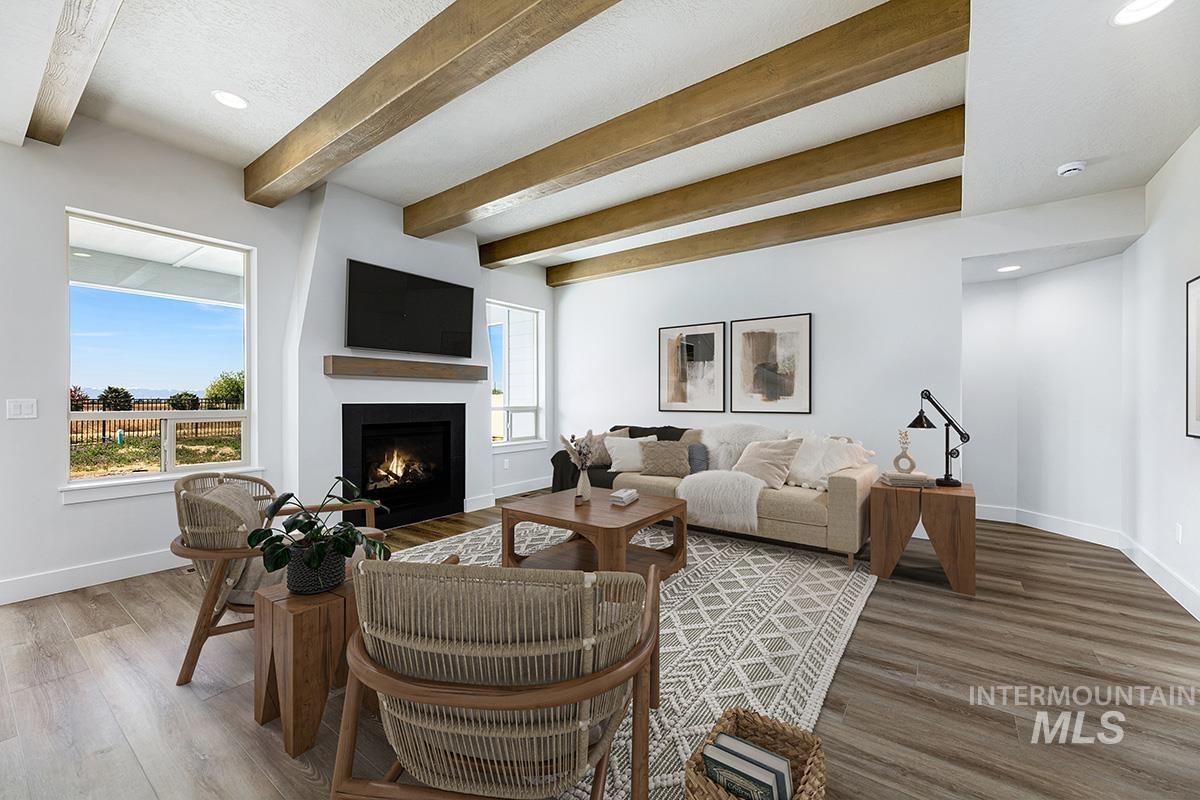 Living room featuring a fireplace with flush hearth, recessed lighting, beam ceiling, and wood finished floors