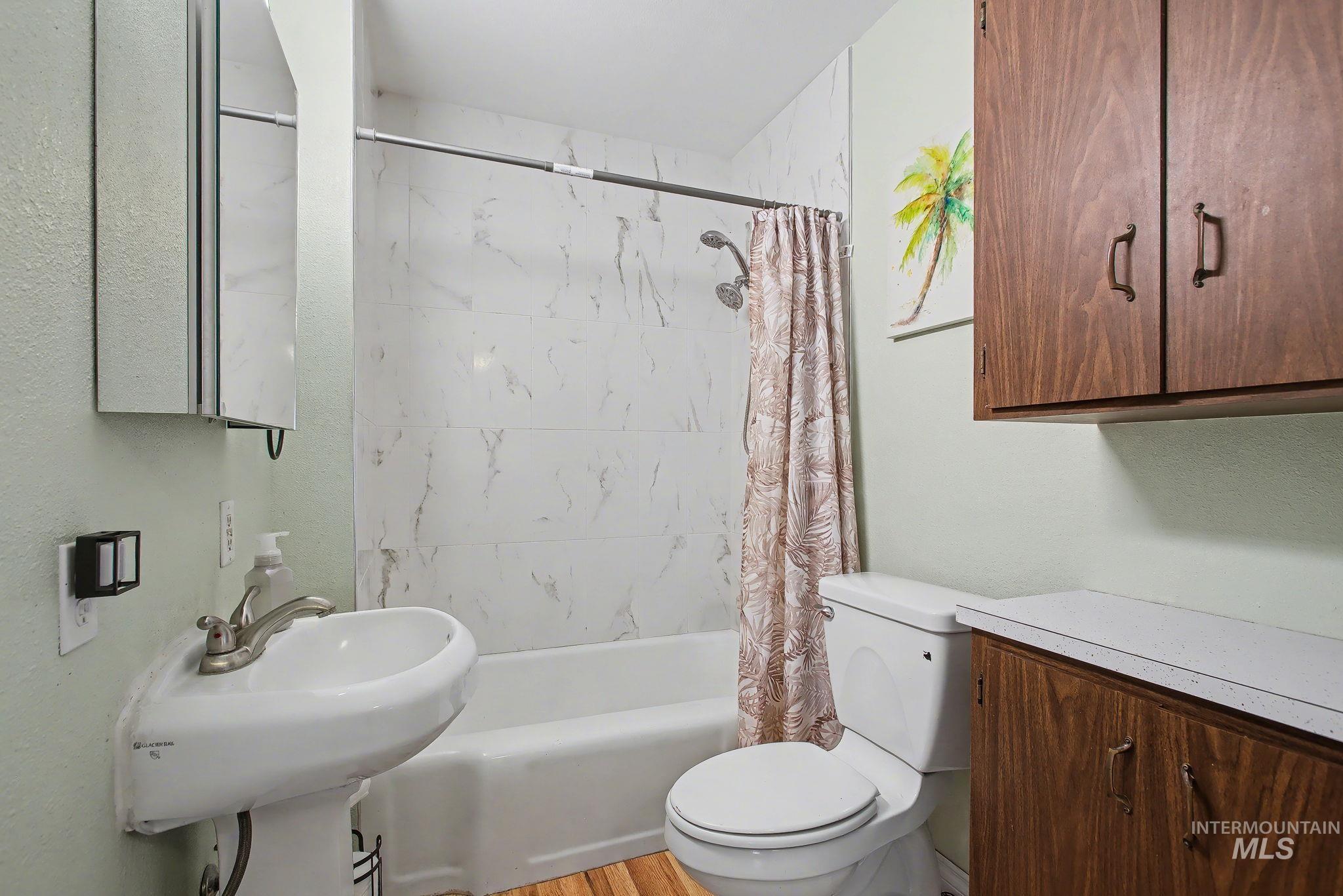Bathroom with shower / tub combo with curtain and toilet