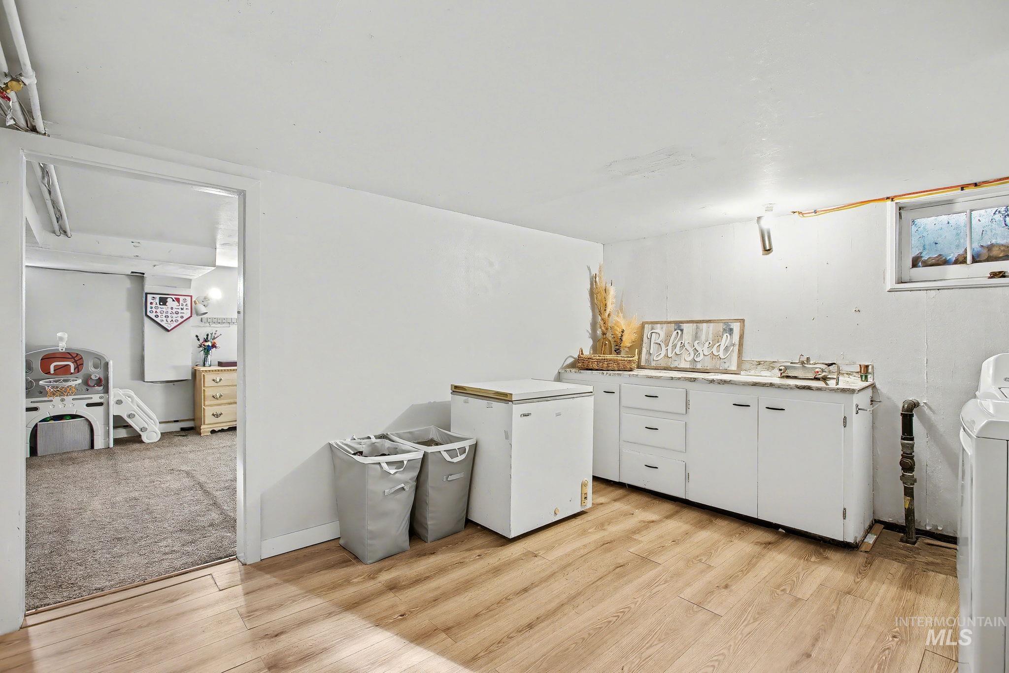 Laundry area with light wood finished floors and washer / clothes dryer
