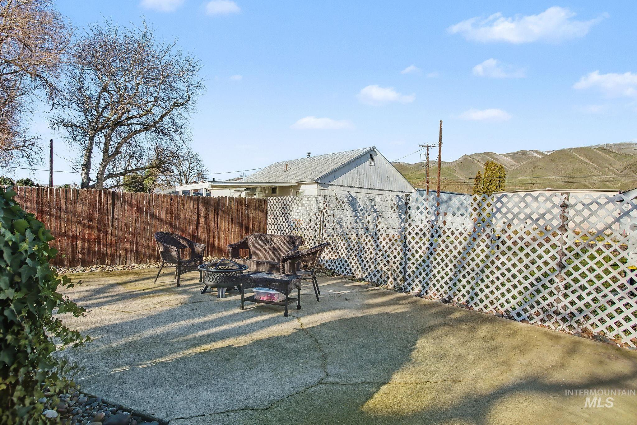 Fenced backyard featuring an outdoor fire pit and a patio