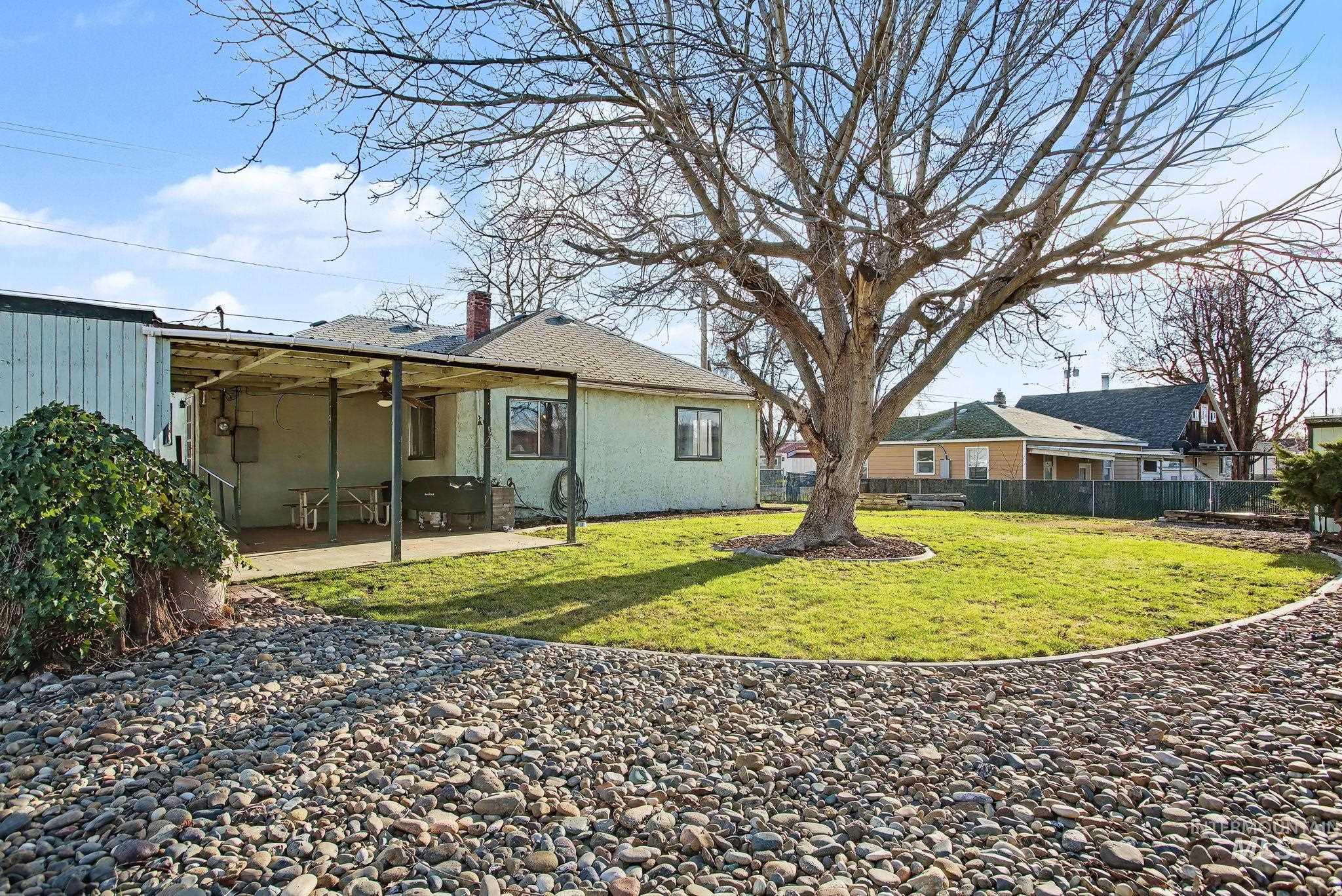 Back of property featuring a fenced backyard, a patio area, stucco siding, and a chimney